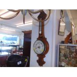 A carved Walnut thermo/ barometer by Haskell