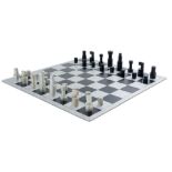 Huszar, Vilmos. Schachspiel. Spielbrett aus Aluminium mit schwarz eloxierten Feldern, Unterseite mit