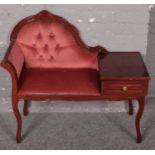 A mahogany deep buttoned upholstered telephone table.