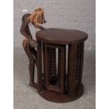 A carved wooden occasional table with CD storage to underneath, African tribal theme.