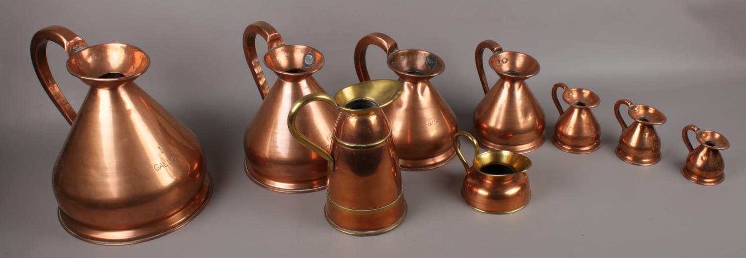 A quantity of copper jugs to include graduated examples.