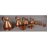 A quantity of copper jugs to include graduated examples.
