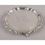 A silver presentation salver raised on four ball and claw feet, assayed 1922 by James Dixon & Sons