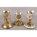 Three brass torsion clocks, to include two Koma examples and a Tempora example with British Rail