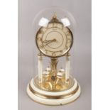 A Hermle torsion clock under glass dome, height 30cm.