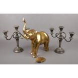 A pair of Ianthe silver plated candlesticks, along with a brass model of an elephant. Elephant