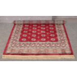 A red ground Kashmir rug with Bokhara design. (170cm x 120cm).