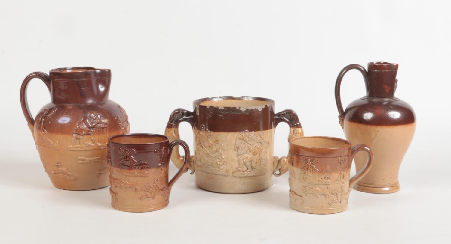 Five pieces of 19th century salt glazed stoneware with sprigged mouldings. A twin handled loving cup