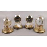 Four small brass torsion clocks under glass domes, to include Schatz, Koma and Kieninger &