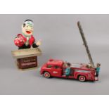 A 1960's tin plate friction drive fire engine & Cragstan battery operated crapshooter novelty toy.