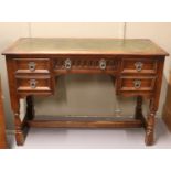 A carved oak leather top desk. (74cm x 107cm)