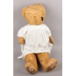 A straw filled teddy in period dress. (72cm tall) Wear to pads. General age wear.