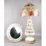 A pottery table lamp with applied floral decoration, along with a similar potter framed circular