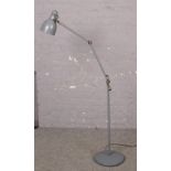 A modern grey adjustable standard lamp. Working.