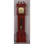 A mahogany long case clock with ornate brass dial.