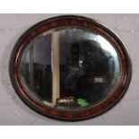 A mahogany framed oval bevel edge wall mirror.