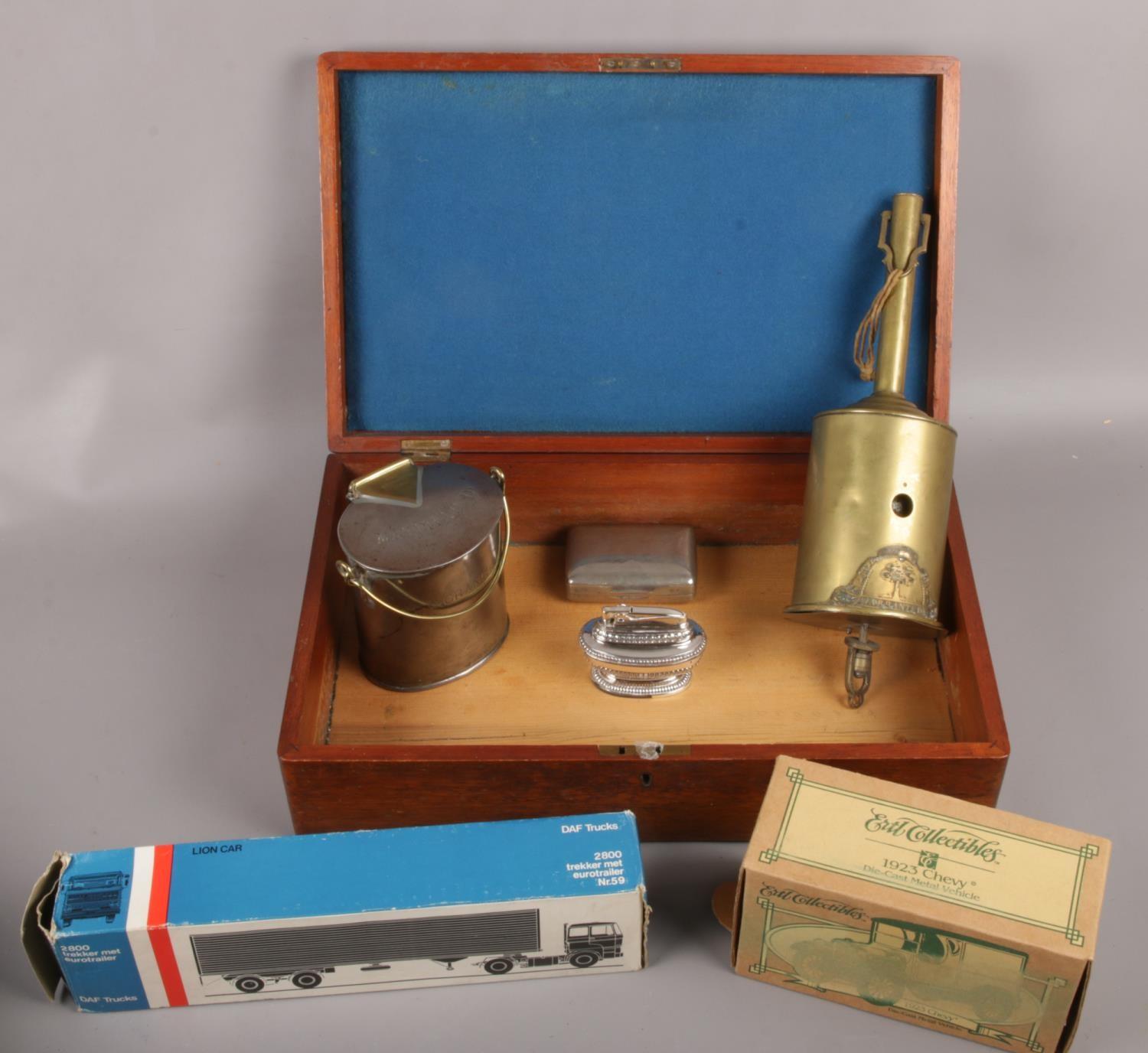 A wooden box of collectables to include Ronson lighter, boxed diecast, metal Britannia Dairy