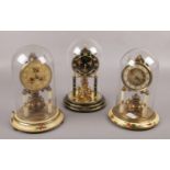 Three German torsion clocks, under glass domes, to include Kundo, Euramca and one other.