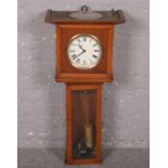 A wooden wall clock with the name of R.F. Seymour, 1930 on the clock face. (Height 91cm x width