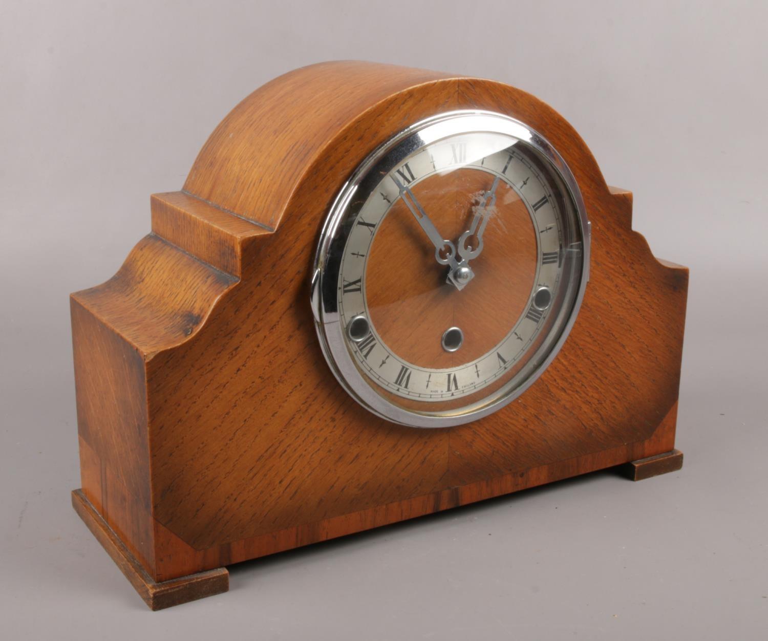 A Norland oak mantel clock, with silvered chapter ring and Westminster chime. Pendulum and key.