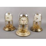 Three brass torsion clocks, under glass domes, Bentima, Kundo examples