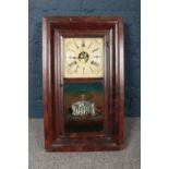 A wall mounted wooden boxed clock with ornate glass front depicting the Merchants' Exchange in