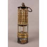 A brass Miner's lamp by 'Wolf Safety Lamp Co of America' with cylindrical lens and swing. H: 30cm.