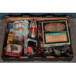 A box of games and toys. Including tin plate vehicles, spud gun, board games, etc.