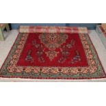 A vintage red ground Persian Tabriz carpet. With bespoke medallion design surrounded by green and