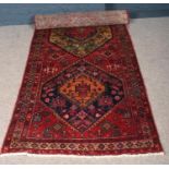 A red ground multicoloured Persian Heriz runner. (310cm x 105cm).