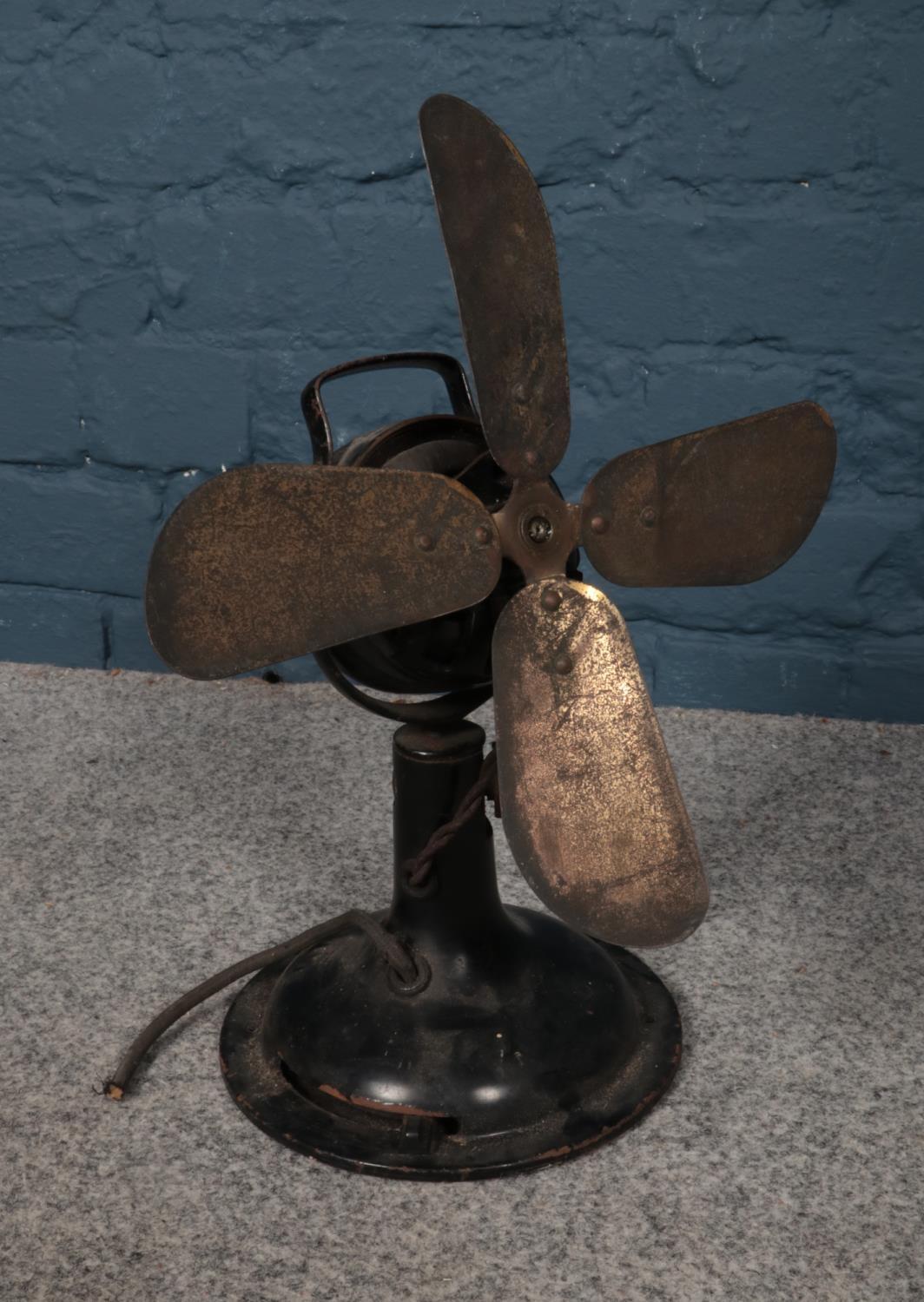 An early 20th century metal table fan. H: 40cm, W: 30cm. Please note that this fan will need a re-