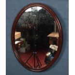 An oval mahogany framed wall mirror.