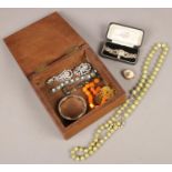 An oak box of costume jewellery. Including white paste stone set cocktail watch, earrings, vintage