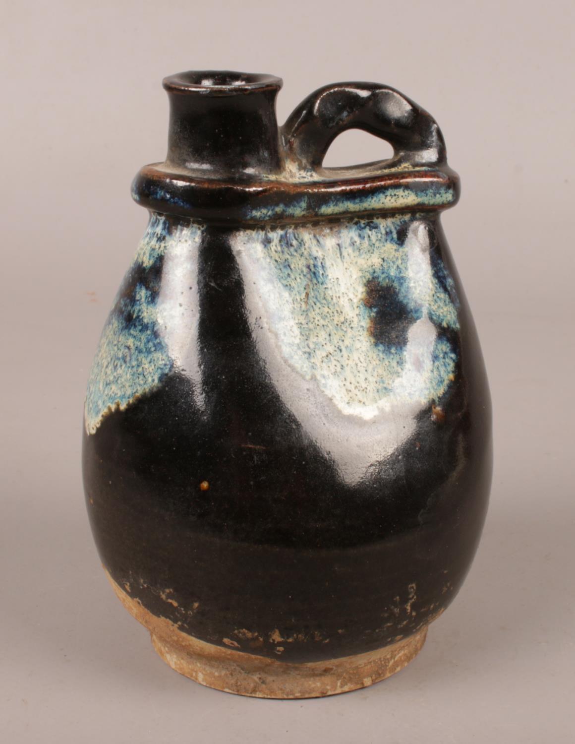 An antique Chinese phosphatic glaze vessel, possibly Tang dynasty. (Height 13cm).