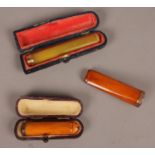 Three ladies cheroot holders. Including 9ct gold and amber examples., etc.