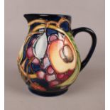 A boxed Moorcroft small jug with fruit decoration (Modern). H:12cm, W: 13cm. Condition good, no
