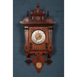 An early 20th Century carved Mahogany wall clock, with pendulum and twin train. H: 96cm, W:44.5cm,