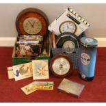 Two boxes of miscellaneous. Quartz wall clocks, Barometers, dvds to include vintage postcards,