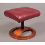 A red leather footstool with wooden base.