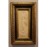 A gilt framed composite plaque depicting a classical maiden and cherub with foundry seal to