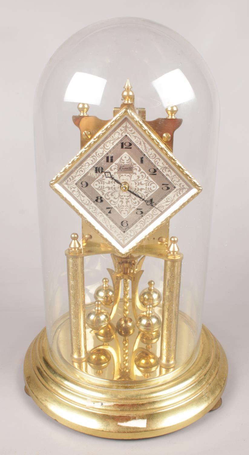 A brass Kundo torsion clock under glass dome. (33cm tall)