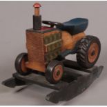 A painted hardwood rocking tractor. H: 71cm, L:79cm, D:44cm. Condition good. A few paint scuffs.