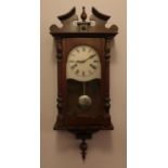 A mahogany cased wall clock. Pendulum and key present.