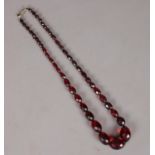 A string of cherry coloured faceted beads.