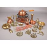 A collection of metalwares. Includes horse brasses, miniature copper kettle, brass candle stick etc.