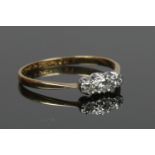 An 18ct gold and platinum ring set with three diamonds. Size P 1/2, 1.63g.