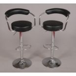 A pair of bar stools with chrome supports.