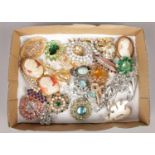 A box of vintage costume brooches. Including paste, rhinestone, cameo examples, etc. One white paste