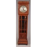 A carved oak cased longcase clock. With three weights and roman numeral marker dial.