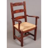 A large mahogany ladder back armchair with rush seat.